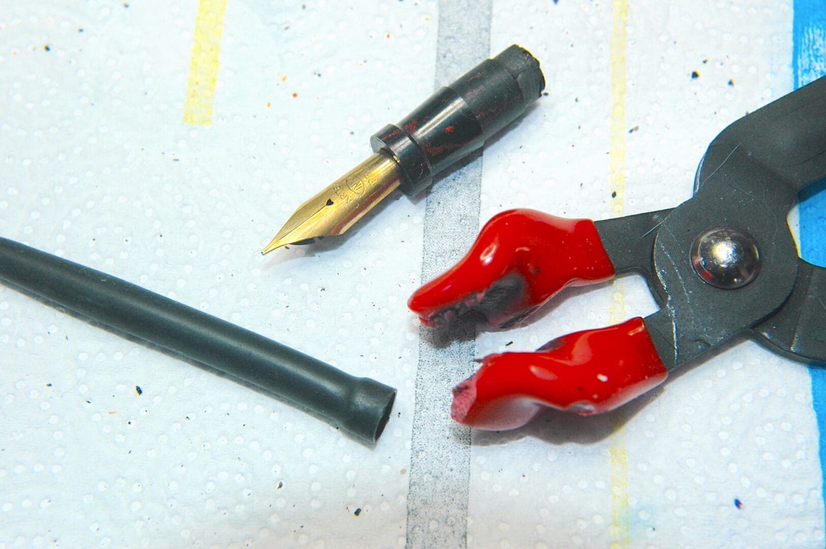 Fountain pen nib with pliers and tubing.