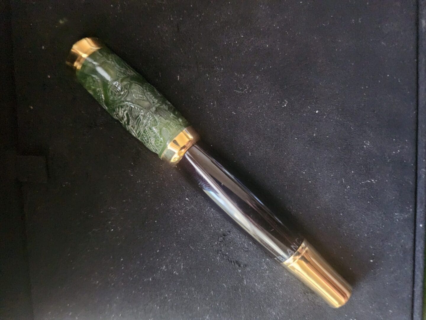 Luxury pen with green and gold design.