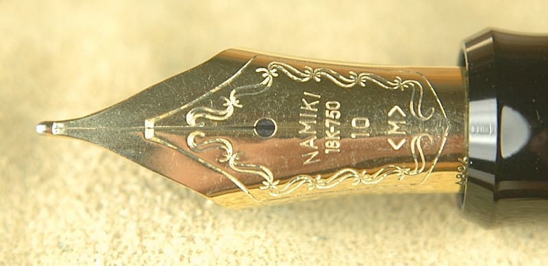 Gold fountain pen nib with intricate engravings.