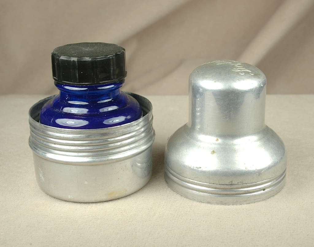 Blue glass bottle in metal container.