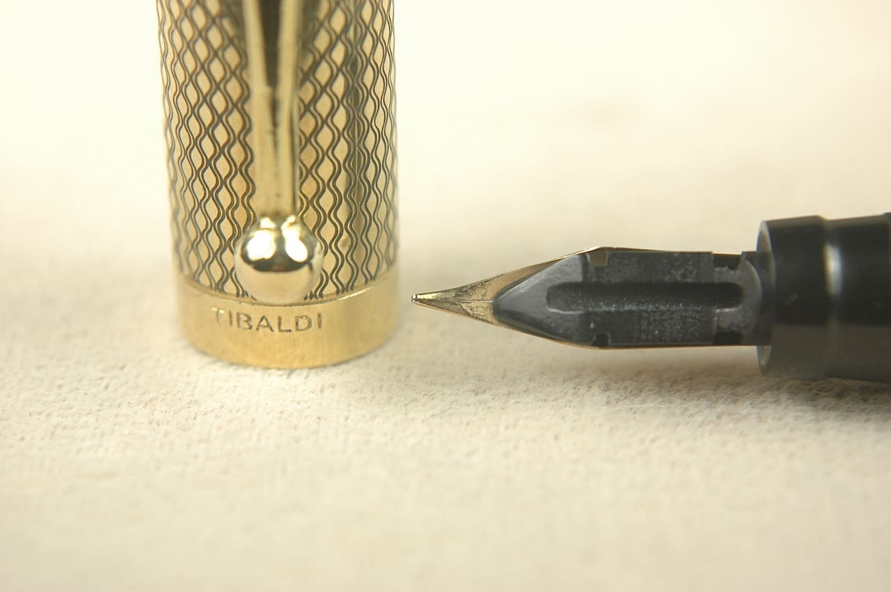 Gold pen cap and black nib close-up.