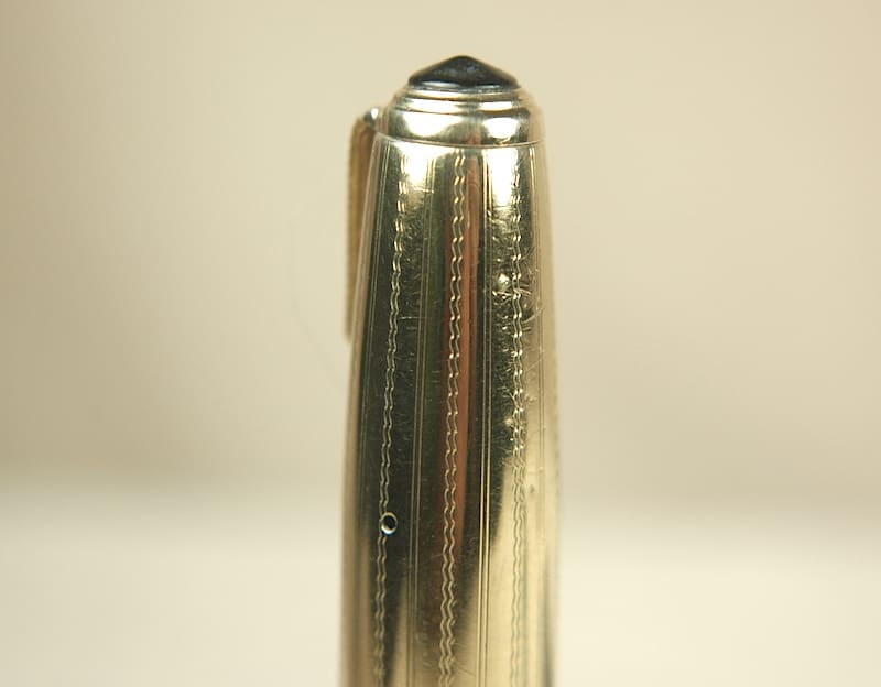 A close-up of a shiny, metallic pen tip with a clip attached.