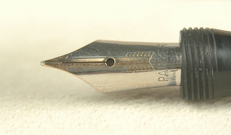 Close-up of a metallic fountain pen nib with fine details.