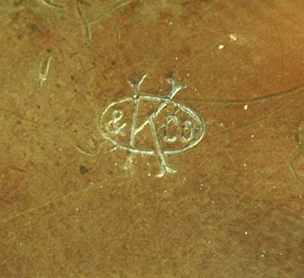 Close-up of a carved symbol on a wooden surface.
