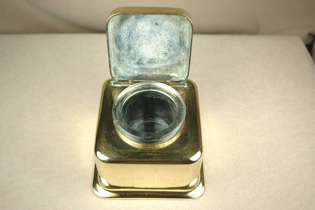 Vintage silver inkwell with hinged lid open.