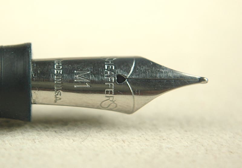 Close-up of a fountain pen nib with engraved text and design.