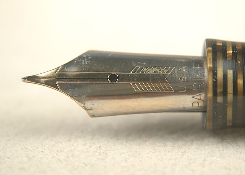Close-up of a vintage fountain pen nib with intricate engravings.
