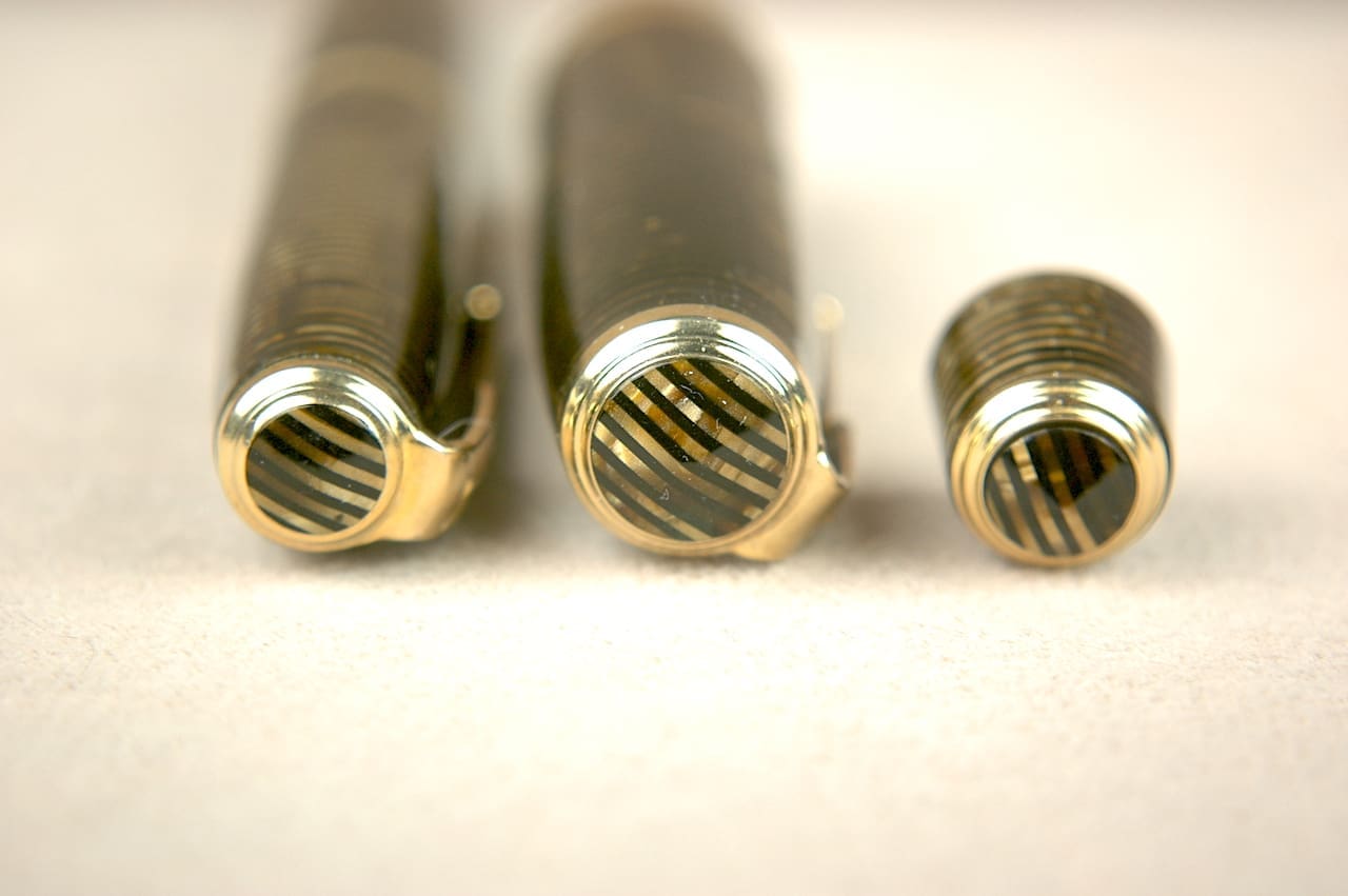 Close-up of three threaded metal rods of different sizes.