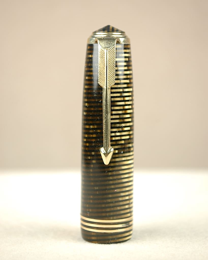 Close-up of a fountain pen nib and cap with gold accents.