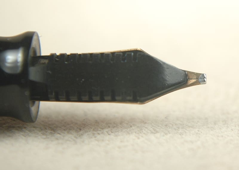 Close-up of a fountain pen nib on a white surface.