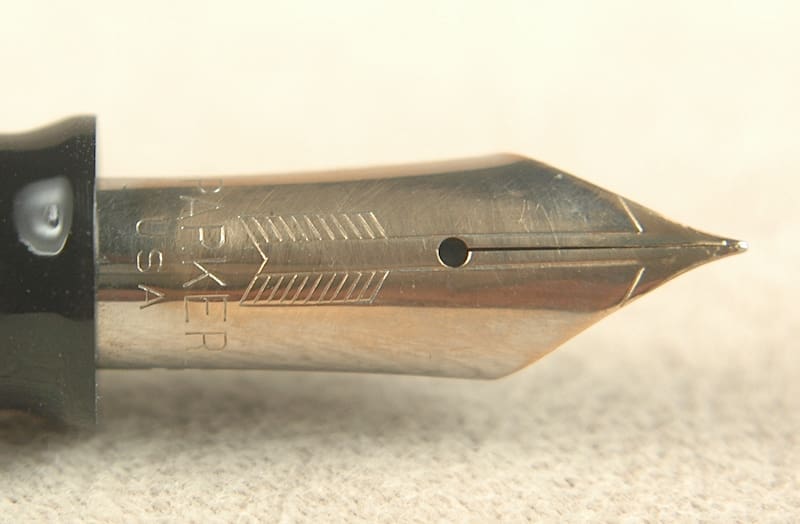 Close-up of a vintage fountain pen nib with intricate engravings.