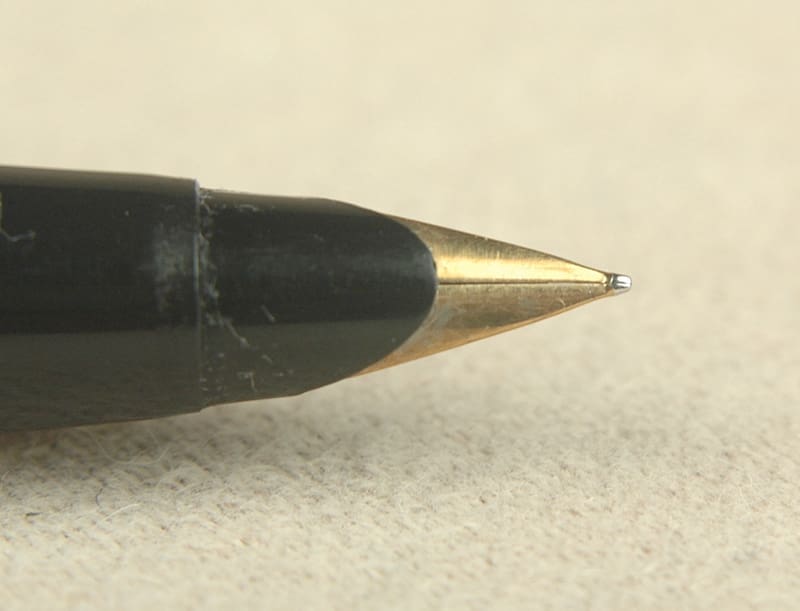 Close-up of a black and gold ballpoint pen tip.