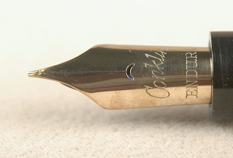 Close-up of a gold fountain pen nib with intricate engravings.