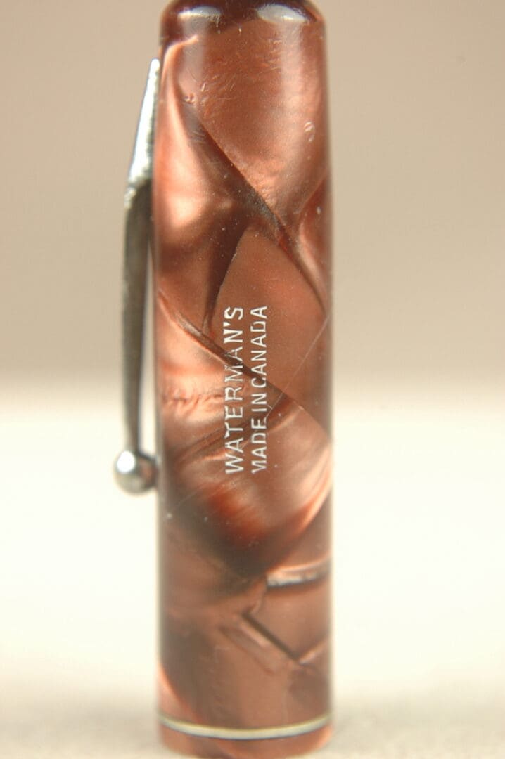 Close-up of a brown marble-patterned pen with text on it.