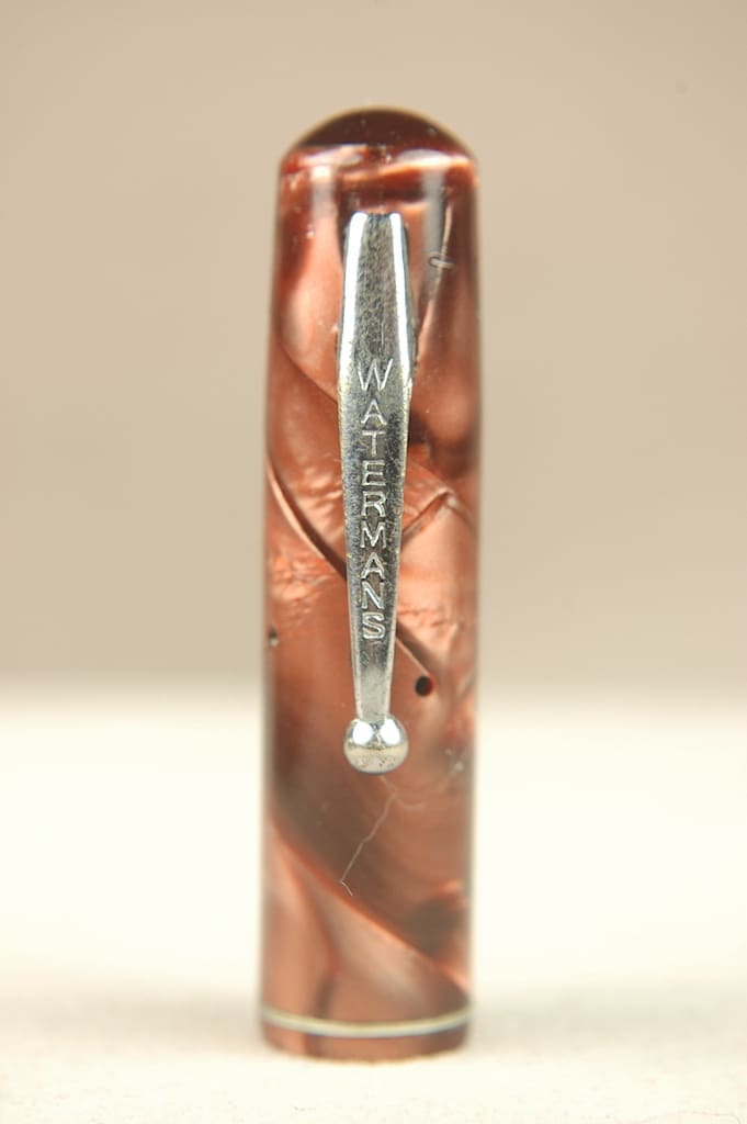 A close-up of a metal tool with engraved text on a patterned surface.