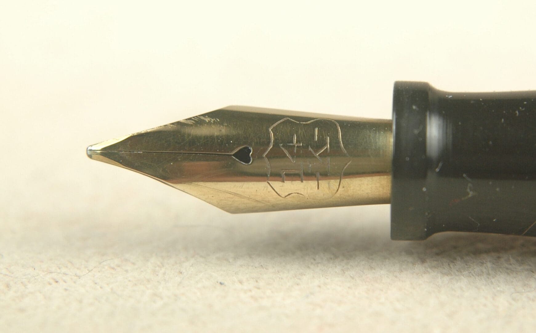 Close-up of a gold fountain pen nib with engraved details.