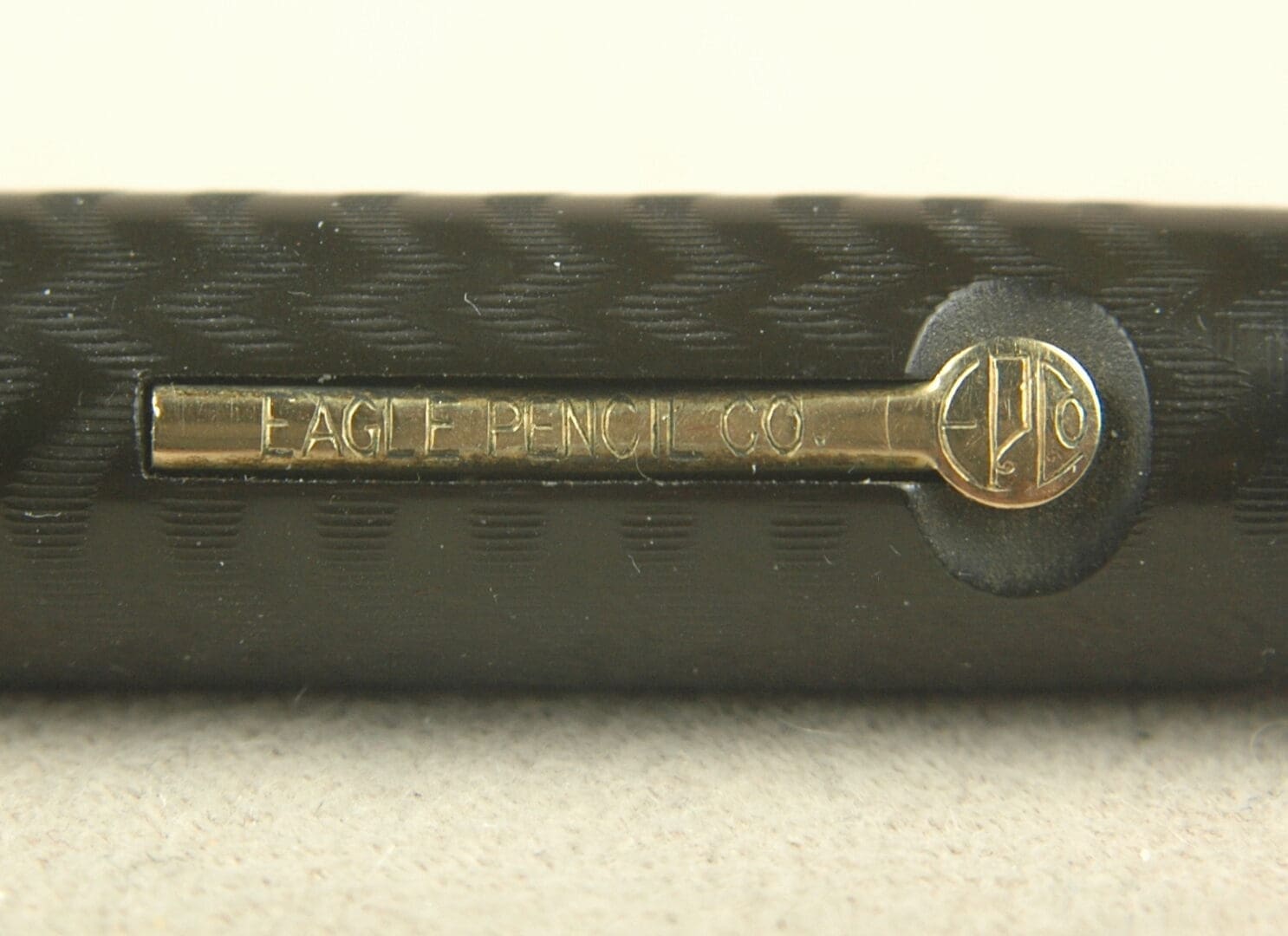 Close-up of a vintage Faberge tie clip with intricate logo design.