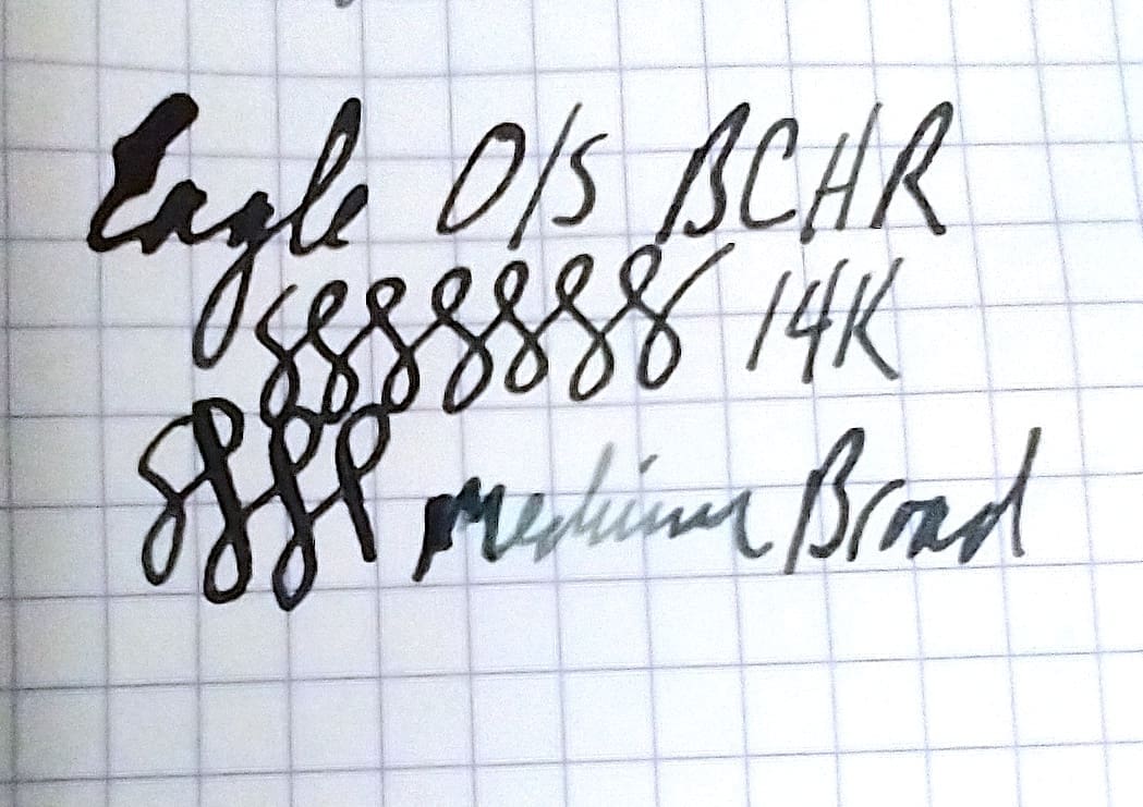 Handwritten ink test on graph paper with different pen types and ink colors.