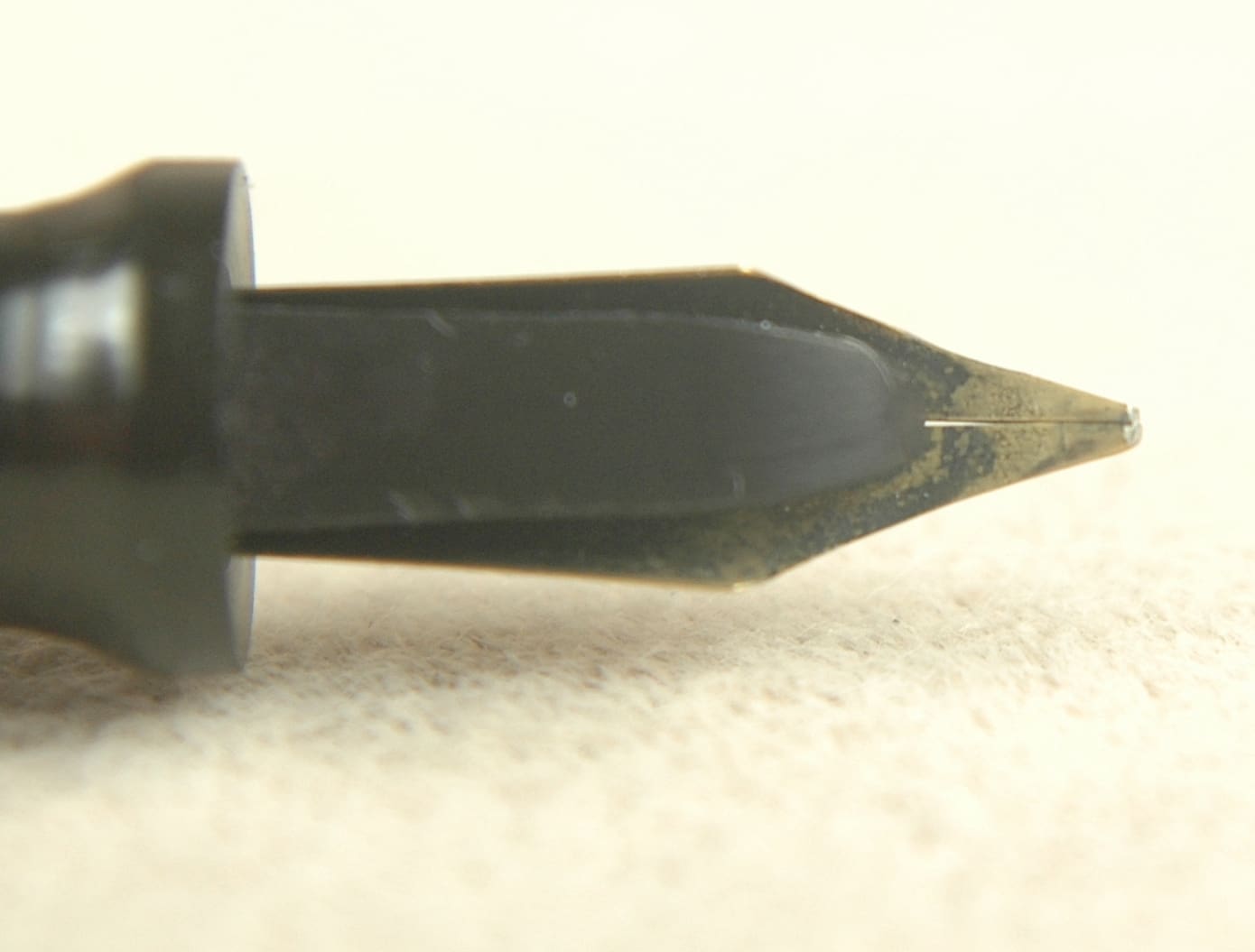 Close-up of a fountain pen nib on a light surface.