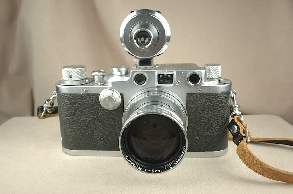 Close-up of a vintage film camera with a large lens and flash attachment.