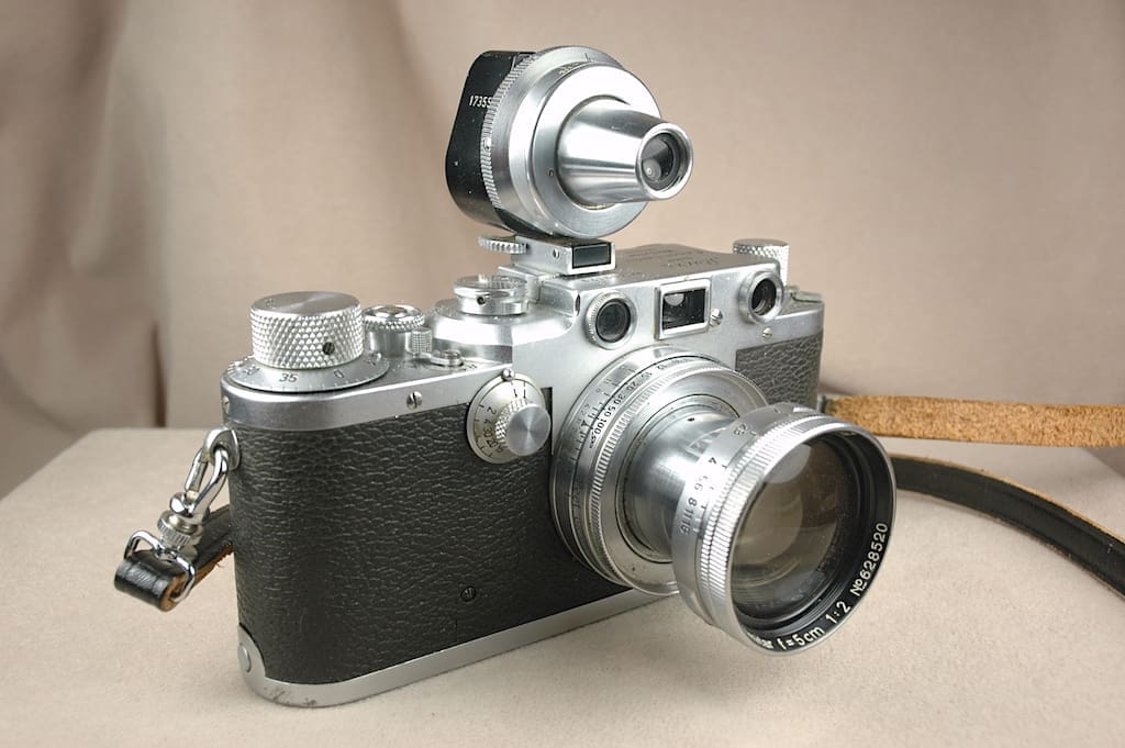 A vintage rangefinder camera with a large external viewfinder attachment.