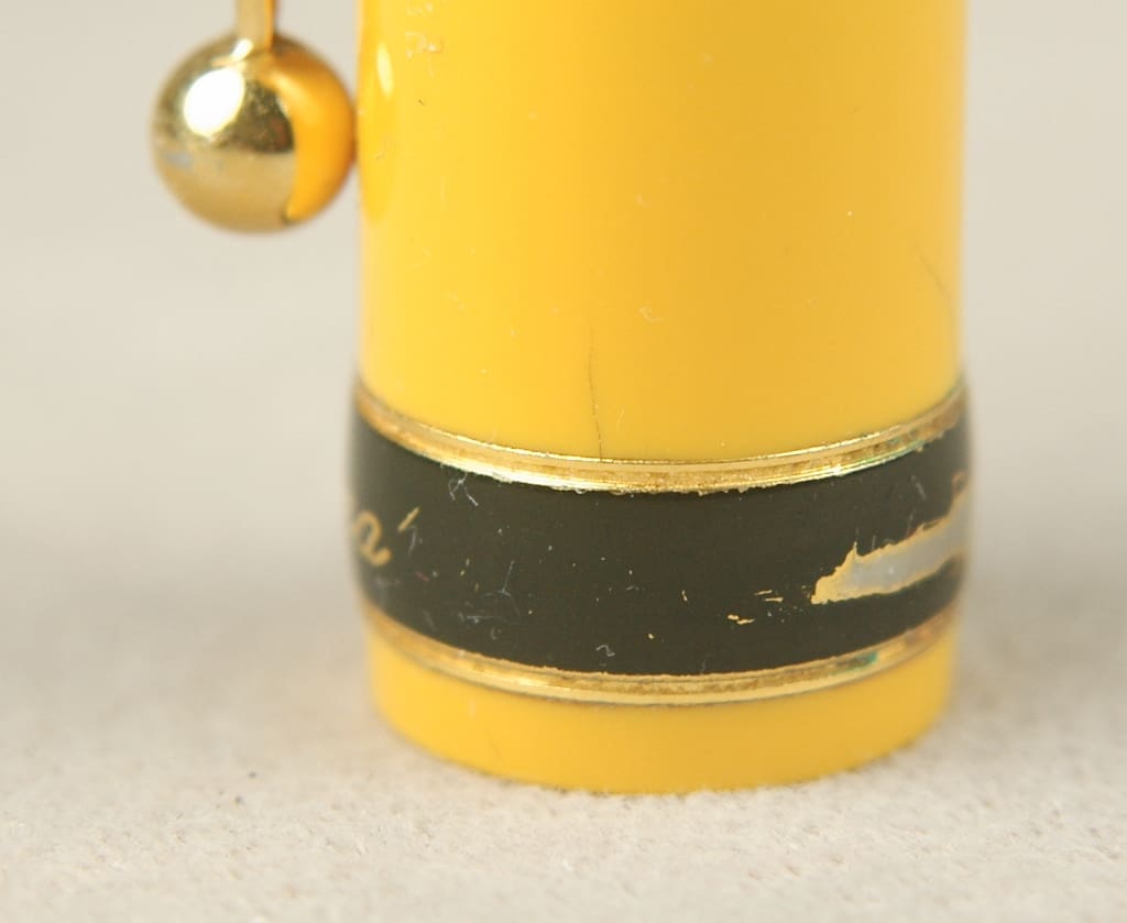 Close-up of a worn yellow pencil tip with a black band.
