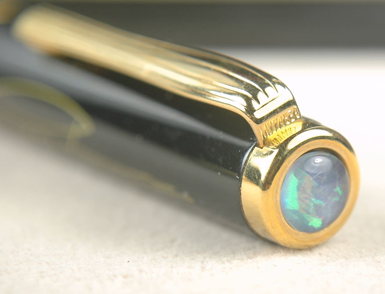 Elegant black and gold pen with a gemstone detail on the end.