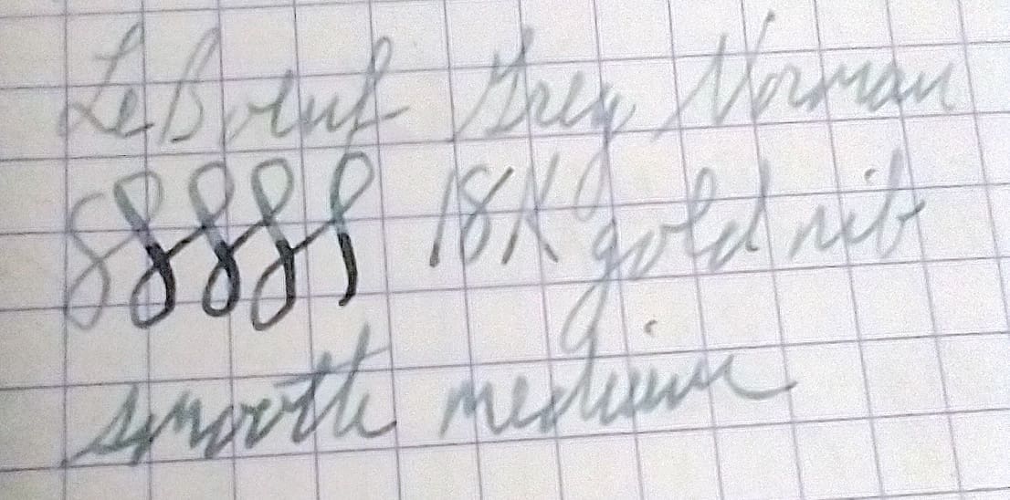 Close-up of handwritten notes on graph paper with cursive writing and numbers.