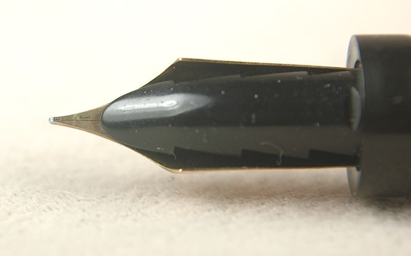 Close-up of a fountain pen nib on a light surface.