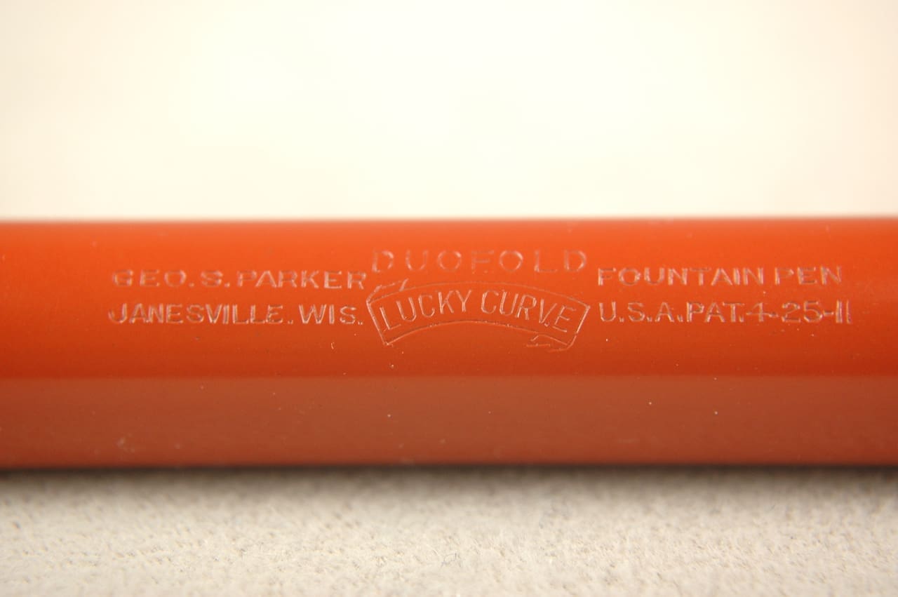Close-up of a red cylindrical object with embossed text.