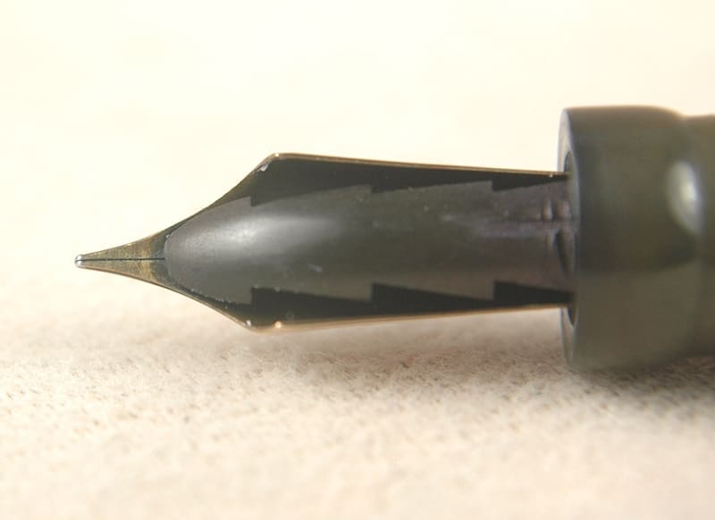 Close-up of a fountain pen nib on a light surface.