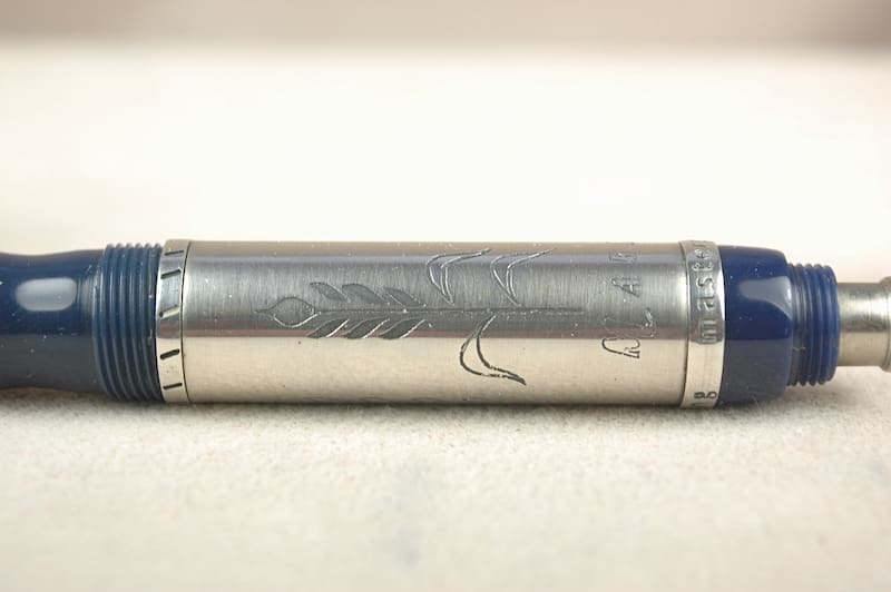 A close-up of a silver metal cylindrical object with engraved markings.