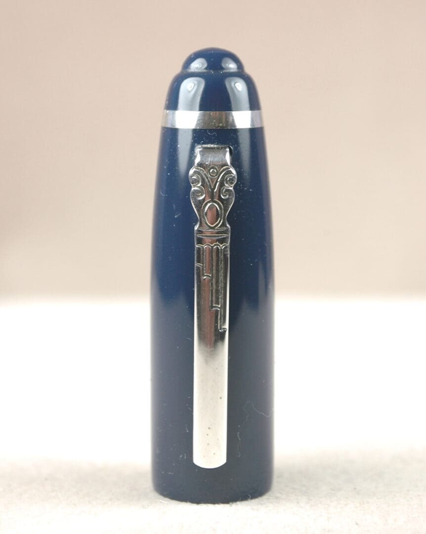 Close-up of a blue fountain pen with a metallic clip and decorative emblem.