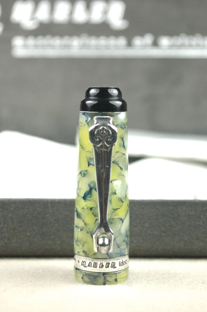 Clear water bottle with lemon slices and a black lid on a gray surface.