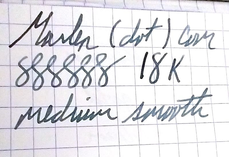 Close-up of handwritten notes on graph paper with cursive writing.