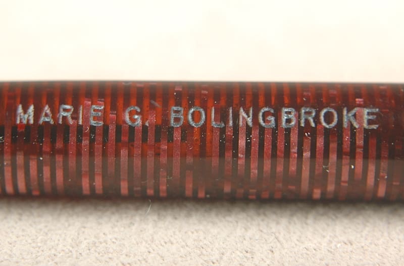 Close-up of a red metal object with engraved text.