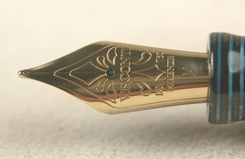 Close-up of a gold fountain pen nib with intricate engravings.